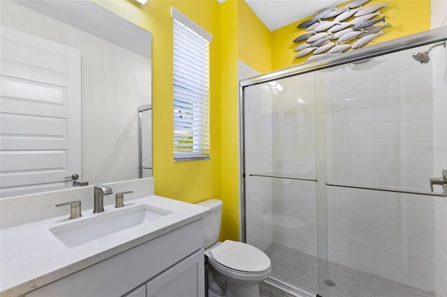 bathroom with toilet, vanity, and an enclosed shower