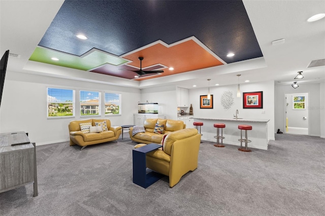 interior space featuring light carpet, ceiling fan, and a tray ceiling