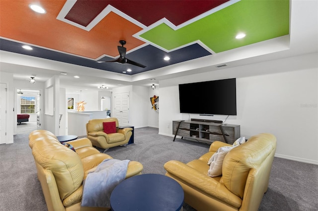 carpeted living room featuring ceiling fan and a raised ceiling