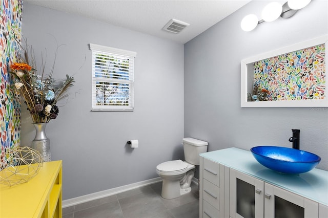 bathroom featuring toilet, vanity, and tile patterned floors