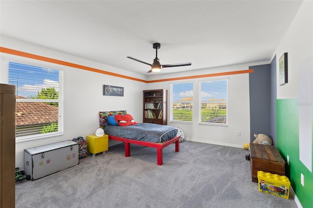 bedroom with ceiling fan, multiple windows, and carpet flooring