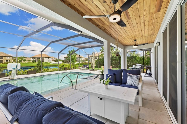 view of patio with glass enclosure, outdoor lounge area, and ceiling fan