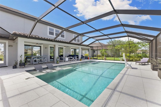 view of swimming pool with ceiling fan, a lanai, and a patio