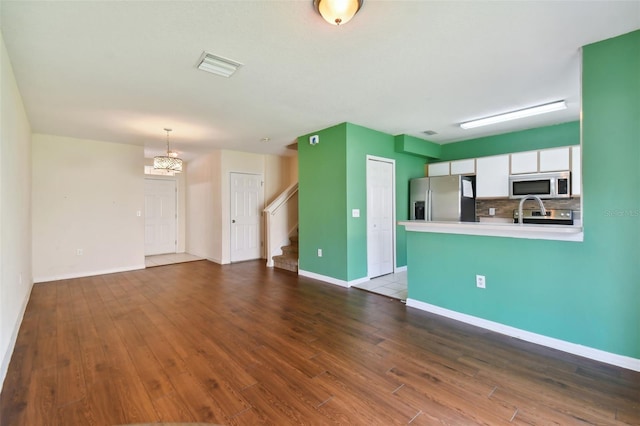 unfurnished living room with a notable chandelier and hardwood / wood-style flooring