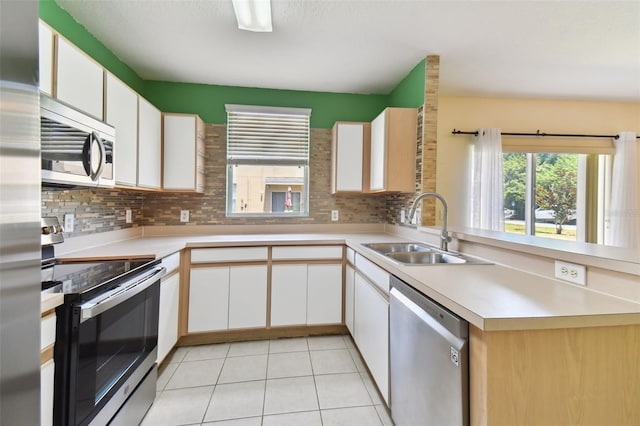 kitchen featuring white cabinets, appliances with stainless steel finishes, sink, and backsplash