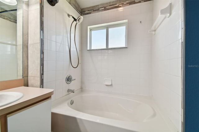 bathroom featuring tiled shower / bath and vanity