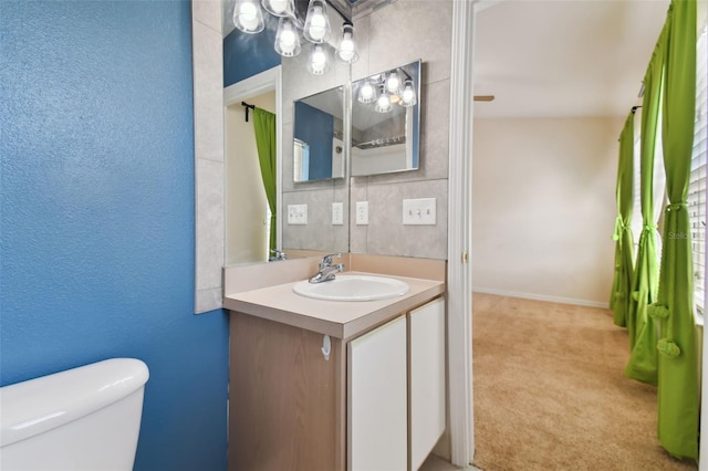 bathroom with vanity with extensive cabinet space and toilet