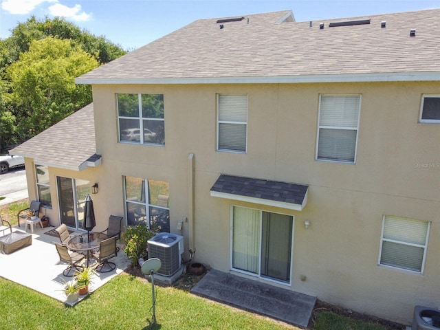 back of property with a patio area, an outdoor living space, central AC unit, and a yard