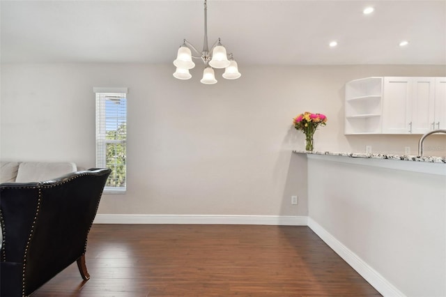 dining room featuring dark hardwood / wood-style floors, sink, and a chandelier