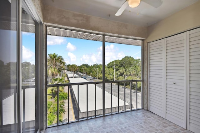 unfurnished sunroom with ceiling fan