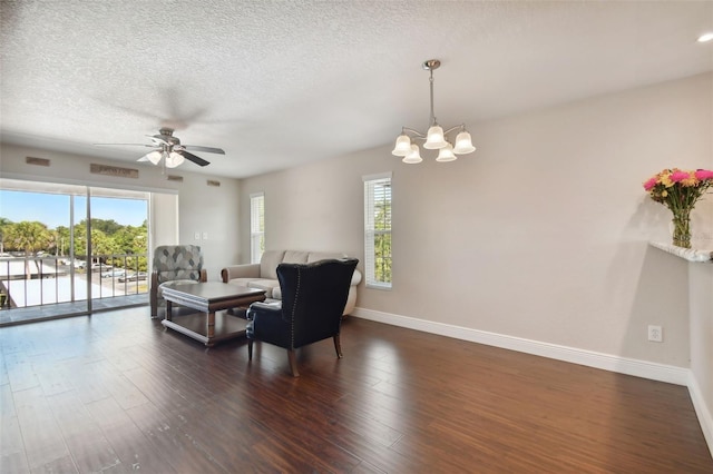 living room with plenty of natural light, a textured ceiling, and dark hardwood / wood-style flooring