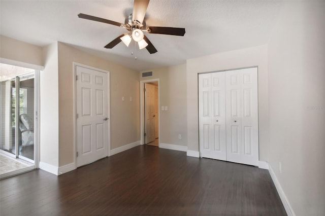 unfurnished bedroom featuring dark wood-type flooring, ceiling fan, access to exterior, and a closet