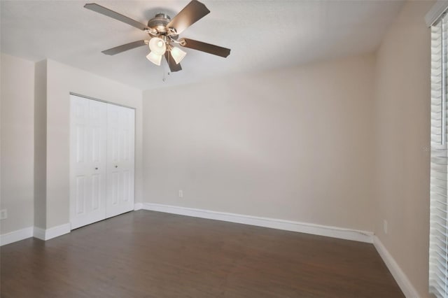 unfurnished bedroom with ceiling fan, dark hardwood / wood-style floors, and a closet