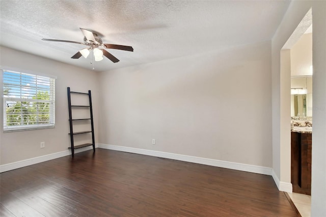 spare room featuring ceiling fan, dark hardwood / wood-style flooring, and a textured ceiling