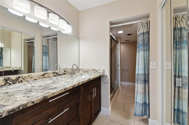 bathroom with tile patterned flooring, vanity, and a shower with shower door