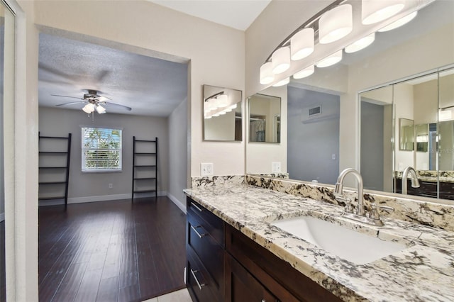 bathroom with hardwood / wood-style flooring, ceiling fan, and vanity