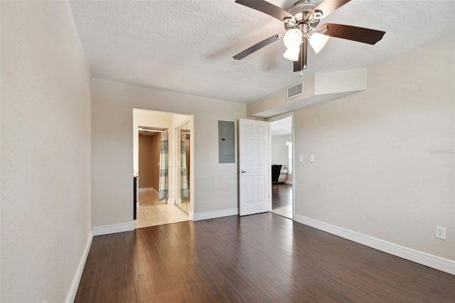 unfurnished room featuring hardwood / wood-style floors, electric panel, a textured ceiling, and ceiling fan