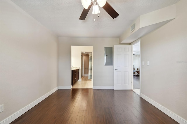 unfurnished room with ceiling fan, electric panel, a textured ceiling, and light wood-type flooring