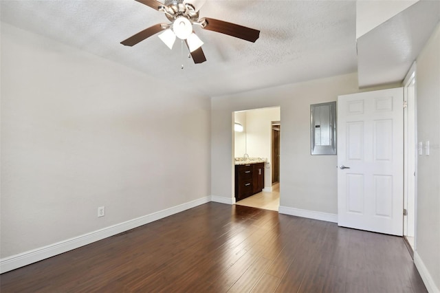 unfurnished bedroom with sink, hardwood / wood-style flooring, electric panel, ceiling fan, and a textured ceiling