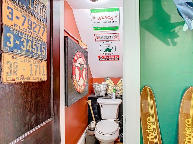 bathroom with toilet and lofted ceiling