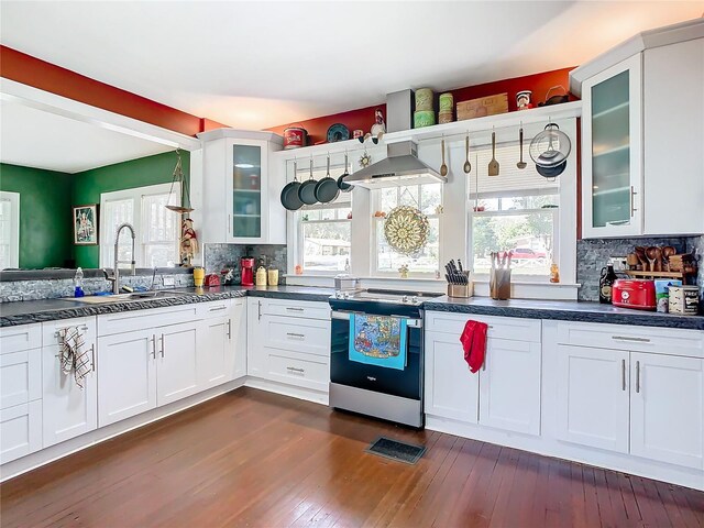 kitchen with tasteful backsplash, sink, wall chimney range hood, white cabinets, and stainless steel electric range oven