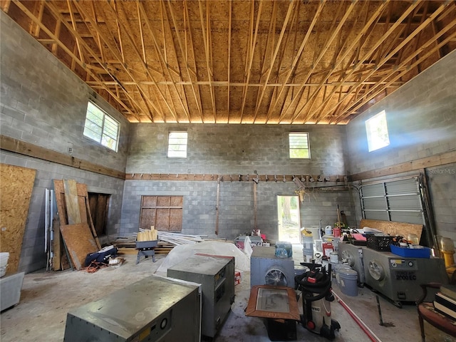 interior space featuring concrete flooring and a towering ceiling