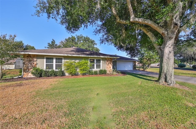 ranch-style house featuring a garage and a front lawn