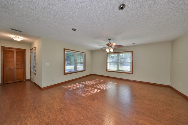 empty room with ceiling fan, a textured ceiling, and hardwood / wood-style flooring