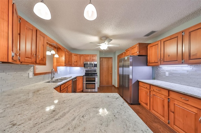 kitchen featuring sink, ceiling fan, hanging light fixtures, and appliances with stainless steel finishes