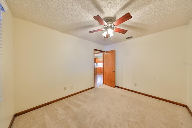 carpeted spare room with a textured ceiling and ceiling fan