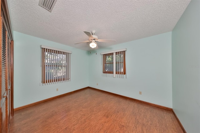 spare room with light hardwood / wood-style floors, a textured ceiling, and ceiling fan