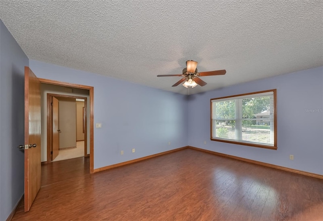 empty room with ceiling fan, a textured ceiling, and dark hardwood / wood-style floors