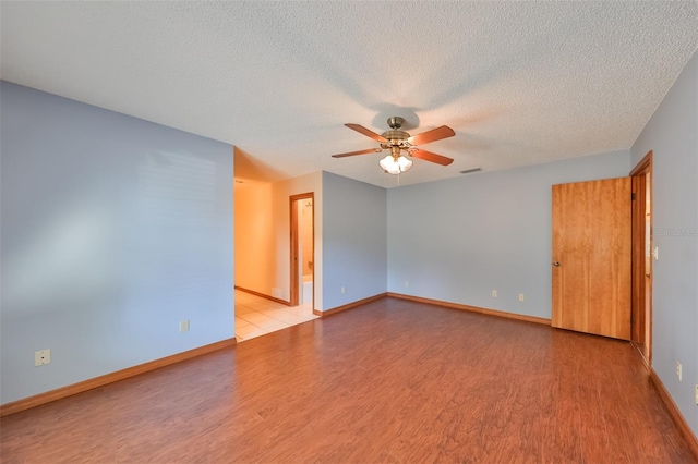 empty room with light wood-type flooring, a textured ceiling, and ceiling fan