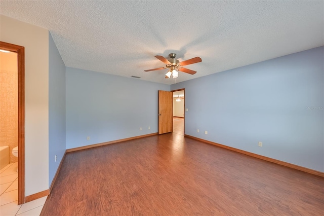 spare room with ceiling fan, a textured ceiling, and hardwood / wood-style flooring