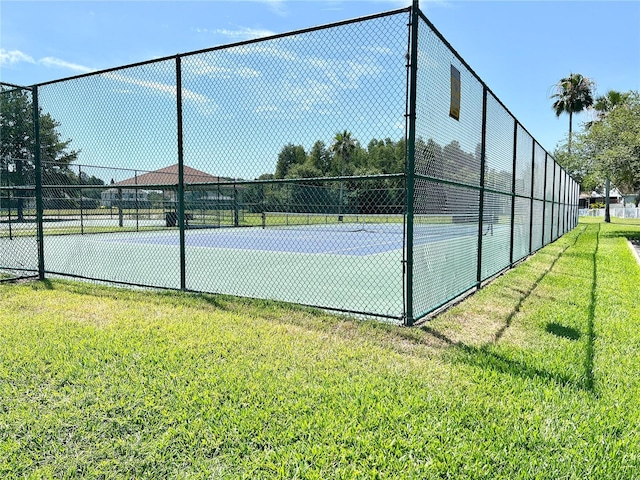 view of tennis court with a lawn