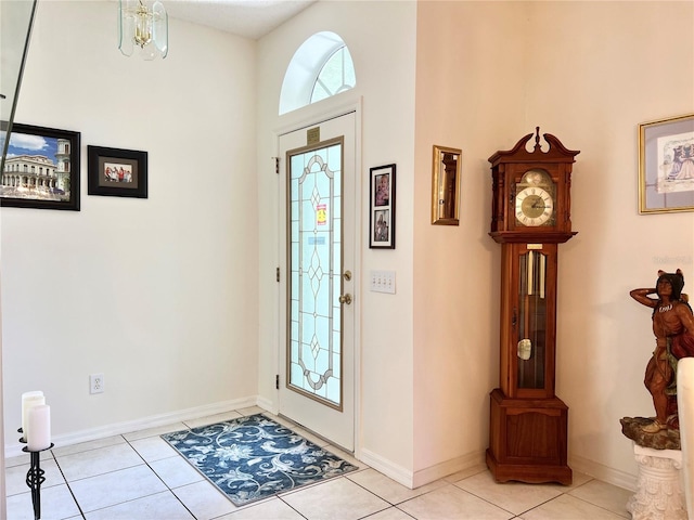 foyer entrance with light tile patterned floors and a notable chandelier