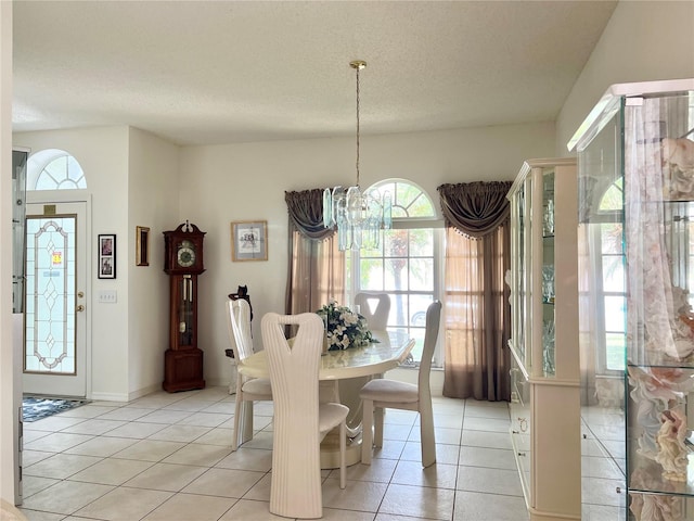 dining space featuring a wealth of natural light, light tile patterned floors, and an inviting chandelier