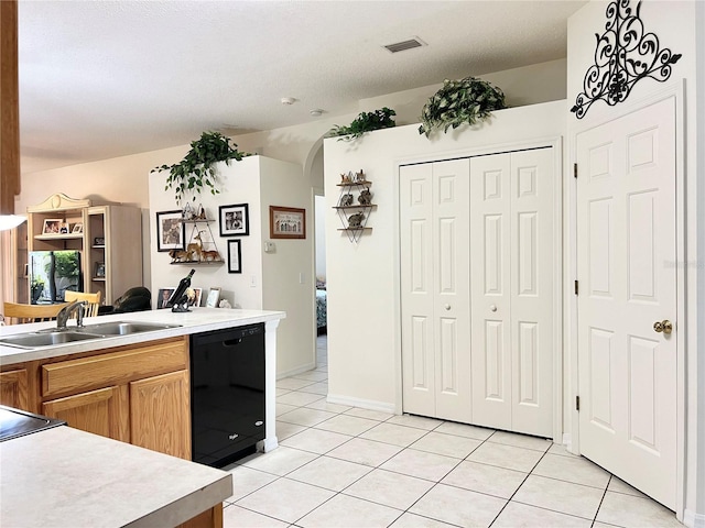 kitchen with light tile patterned flooring, a textured ceiling, black dishwasher, and sink