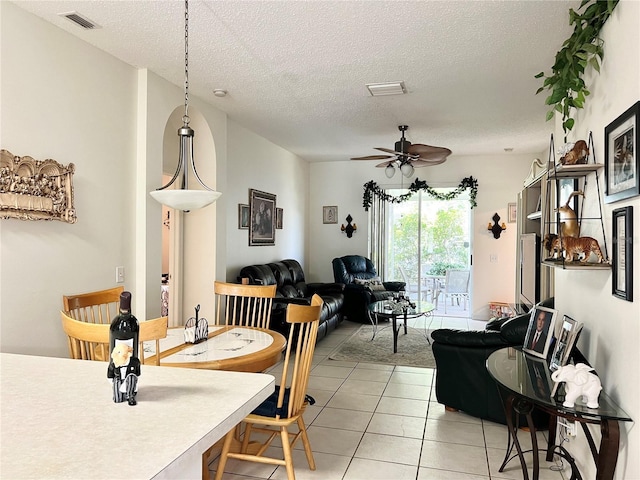 dining space with light tile patterned floors, a textured ceiling, and ceiling fan