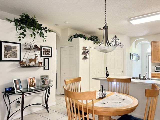 tiled dining room featuring a textured ceiling