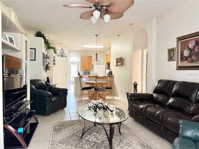 tiled living room featuring a textured ceiling and ceiling fan