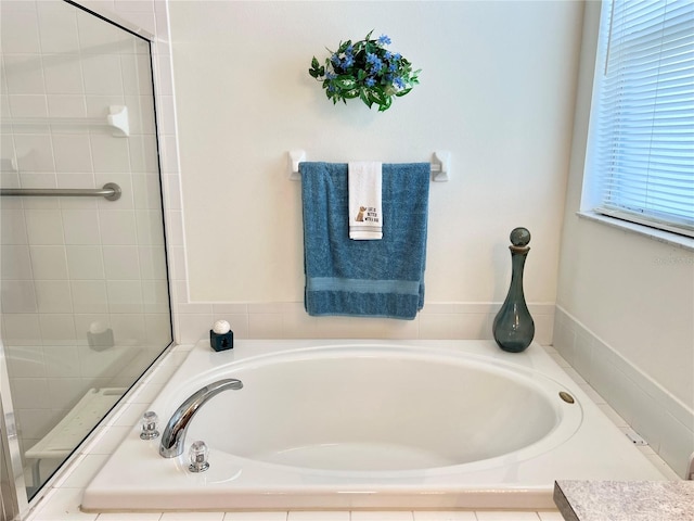 bathroom featuring a relaxing tiled tub and vanity