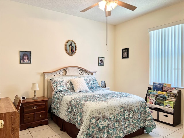 tiled bedroom featuring ceiling fan and a textured ceiling