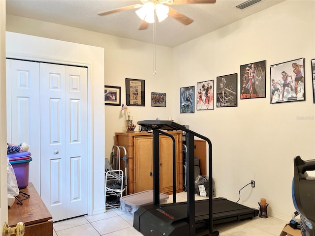 exercise room featuring ceiling fan and light tile patterned floors