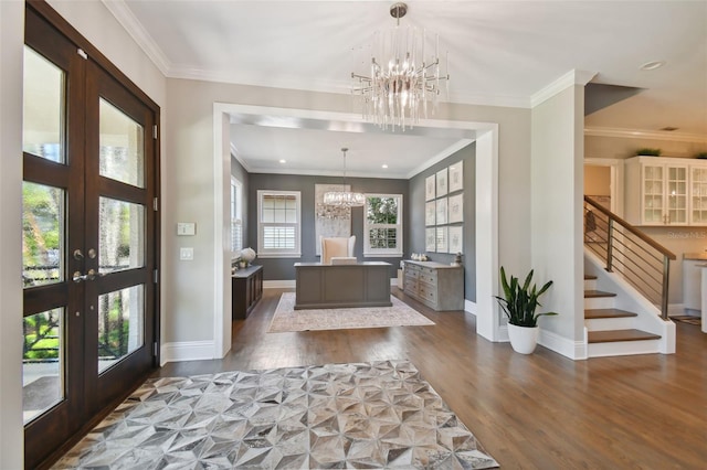 foyer featuring a notable chandelier, french doors, crown molding, and hardwood / wood-style floors