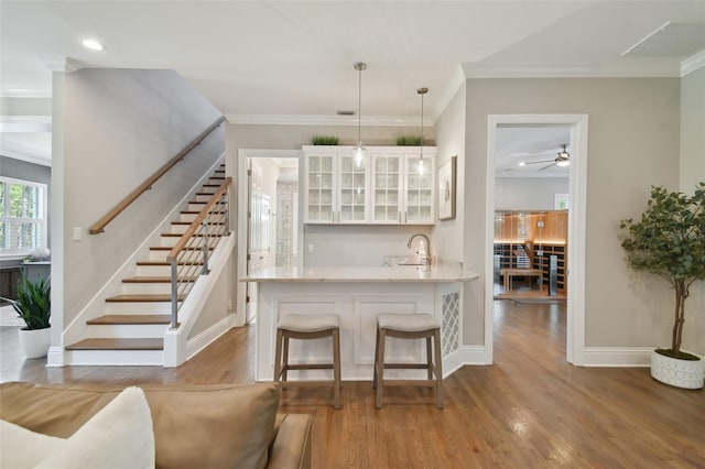 kitchen featuring a breakfast bar, white cabinetry, kitchen peninsula, and light hardwood / wood-style flooring