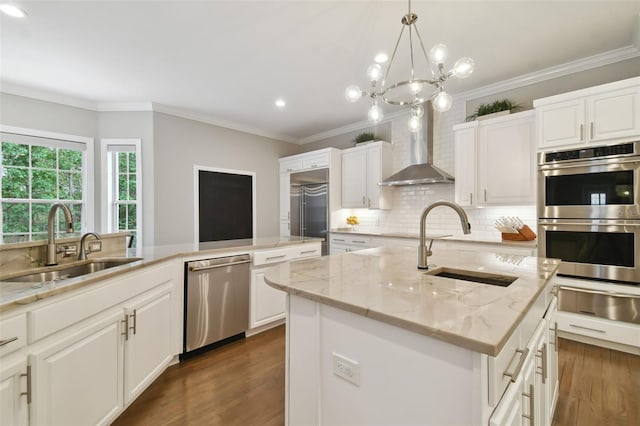 kitchen featuring dark hardwood / wood-style floors, a center island with sink, wall chimney exhaust hood, sink, and appliances with stainless steel finishes