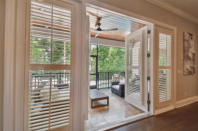 doorway with ceiling fan, crown molding, and hardwood / wood-style flooring