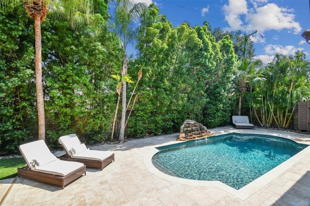 view of swimming pool featuring pool water feature and a patio area