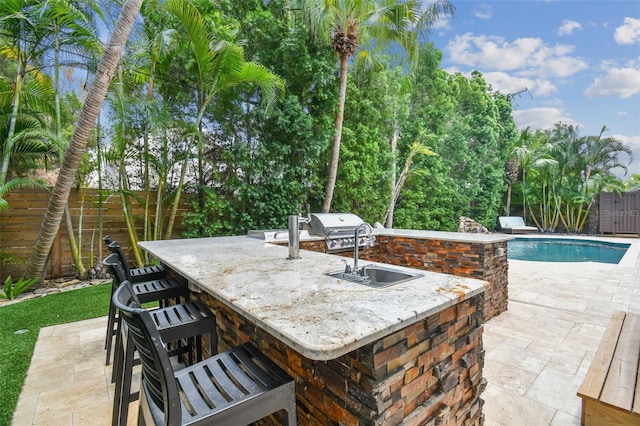 view of patio with an outdoor kitchen, an outdoor wet bar, and grilling area